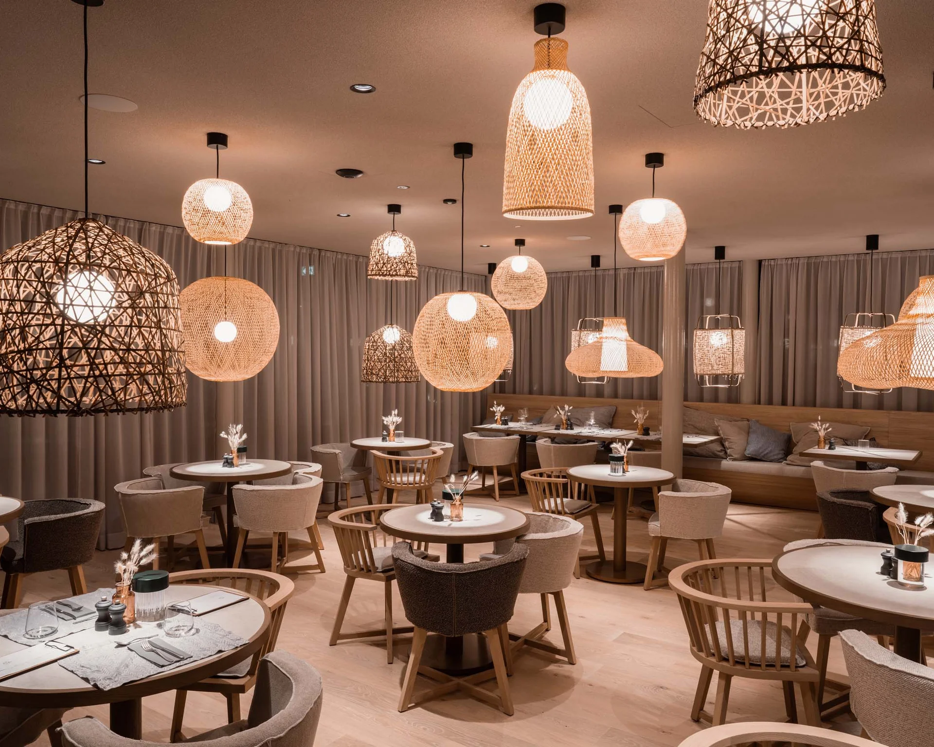 NILS am See: Impressionen eines Orts für das süße Leben Gemütliches Restaurant mit Stühlen, Tischen und warmen Hängeleuchten