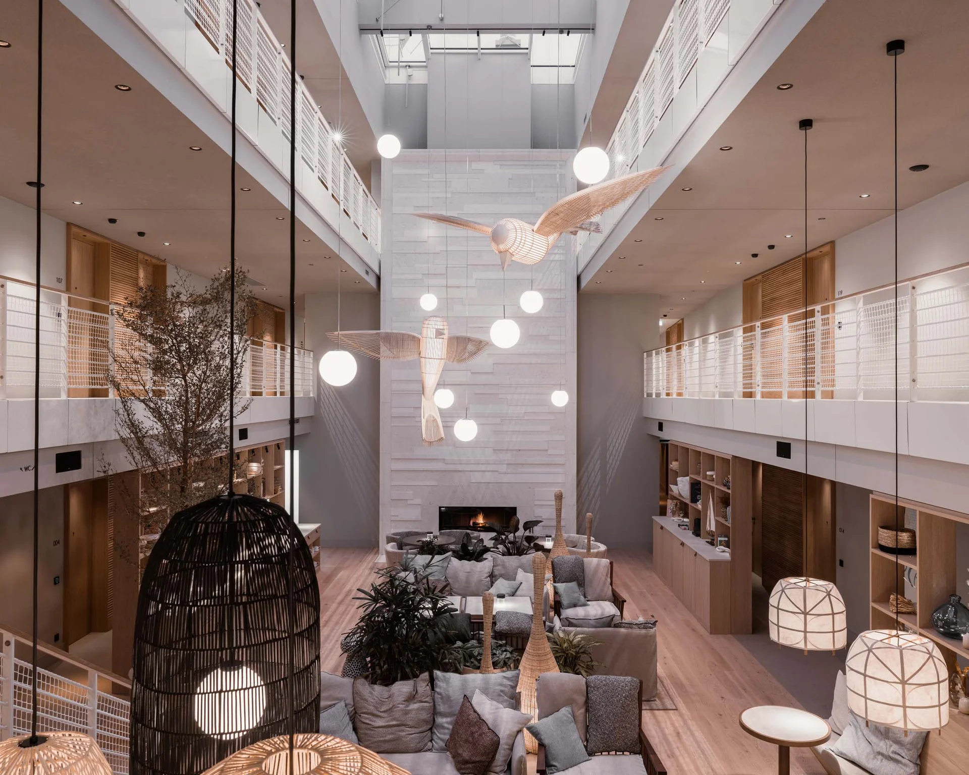 NILS am See: Impressionen eines Orts für das süße Leben Modernes Hotelinterieur mit hängenden Vogelskulpturen und gemütlichen Sitzbereichen