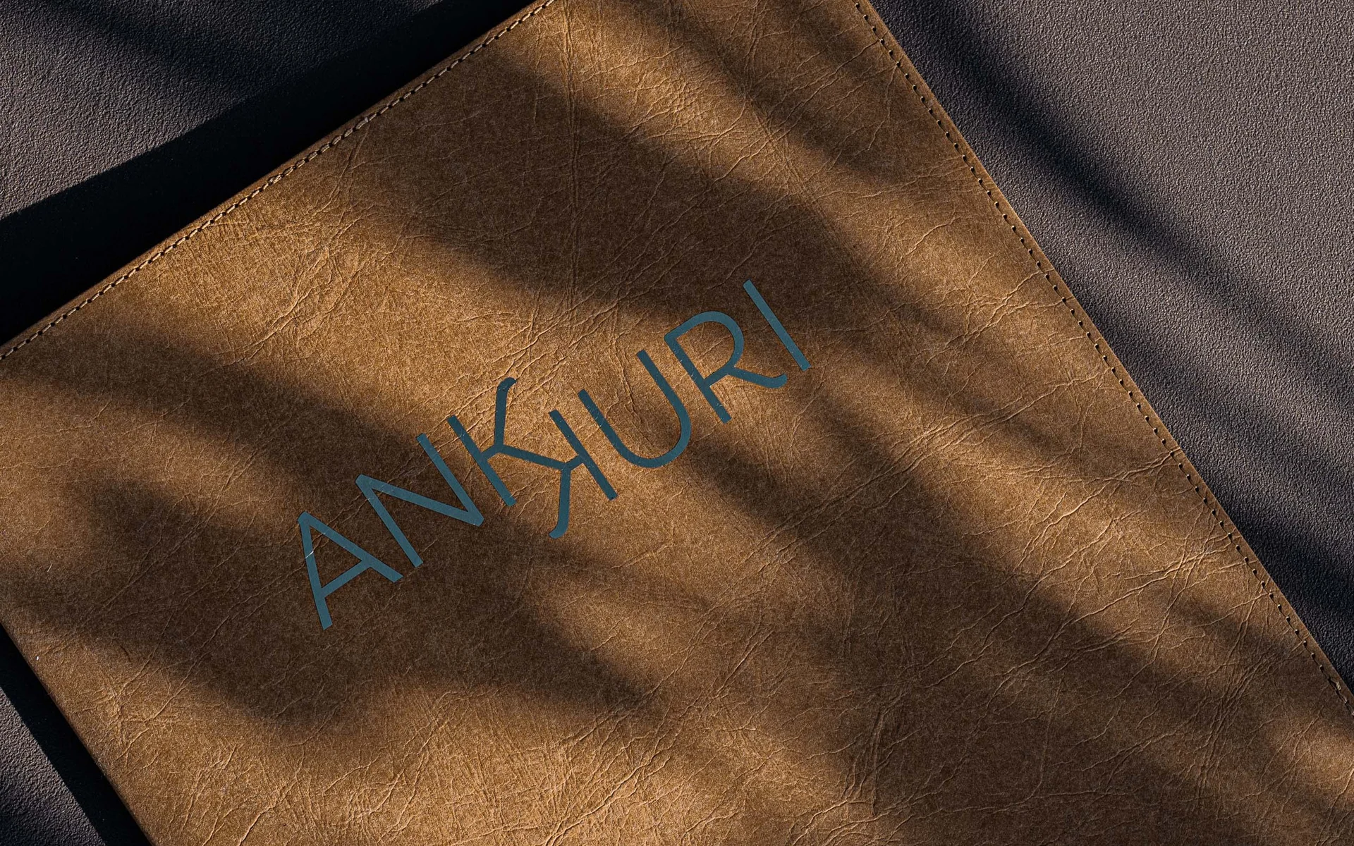 Restaurant Ankkuri am Neusiedler See Braunes Lederetui mit AnkuRi-Logo und Schattenmuster