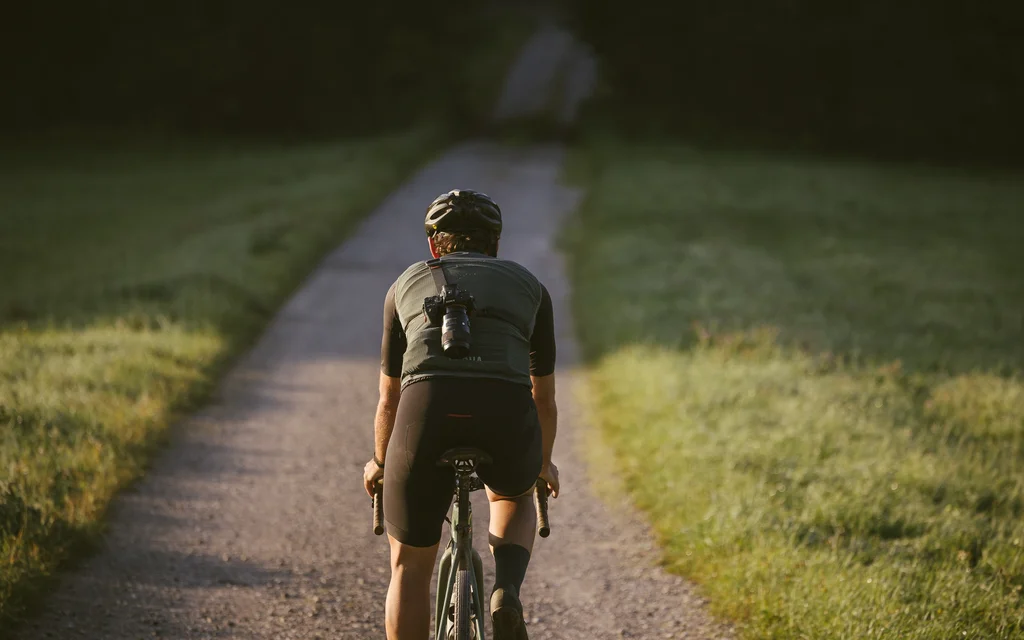 NILS am See: Erlebnisse im Urlaub am Neusiedler See Fahrradfahrer auf schmalem Weg umgeben von Wiese bei Sonnenlicht