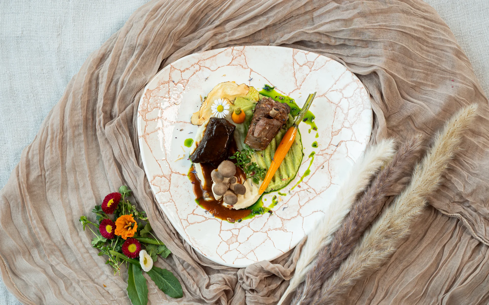 Restaurant Ankkuri am Neusiedler See Gourmetgericht mit Fleisch, Karotte, Pilzen und Kräutern auf dekorativem Teller