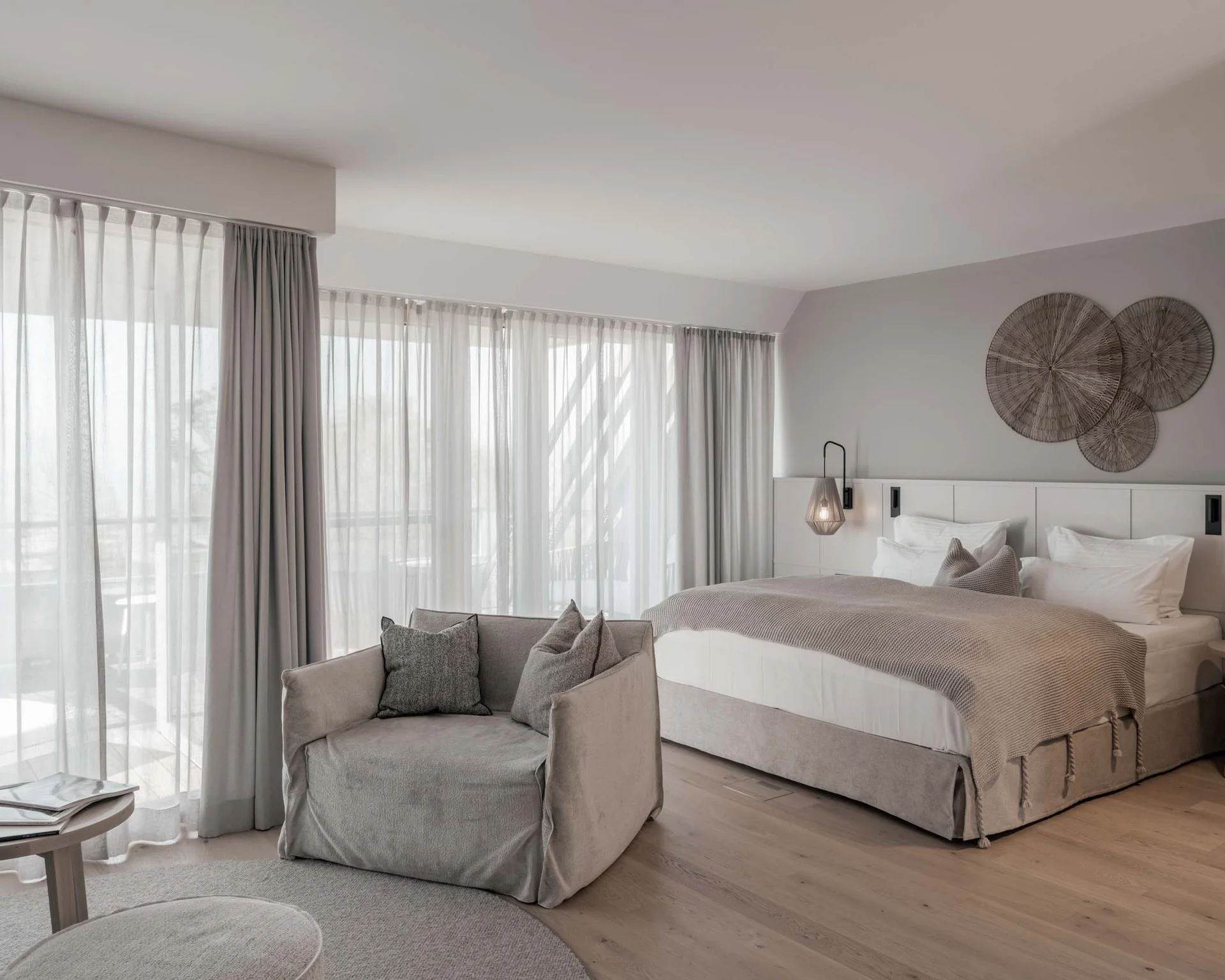 NILS am See: Impressionen eines Orts für das süße Leben Modernes Schlafzimmer mit großem Bett, Sessel, Vorhängen und Wanddekoration