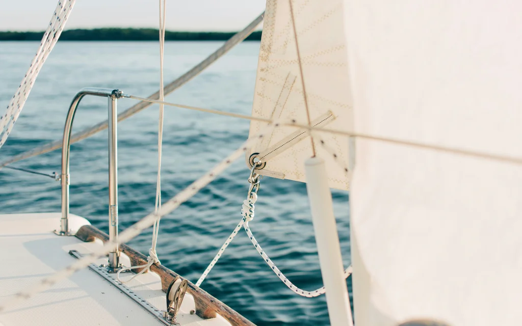NILS am See: Wassersport am Neusiedler See Nahaufnahme eines weißen Segels und Takelage auf einem Segelboot auf dem Wasser