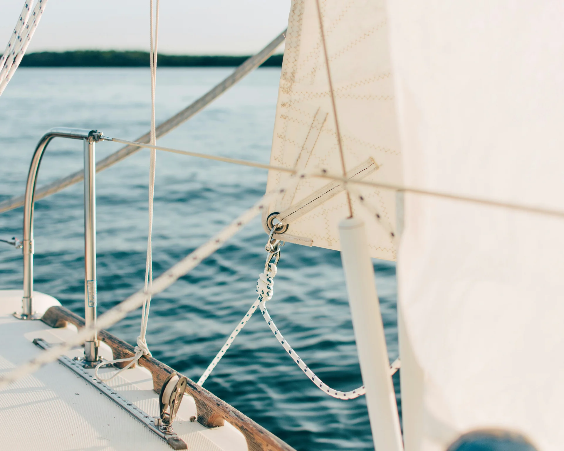 NILS am See: Impressionen eines Orts für das süße Leben Nahaufnahme eines weißen Segels und Takelage auf einem Segelboot auf dem Wasser