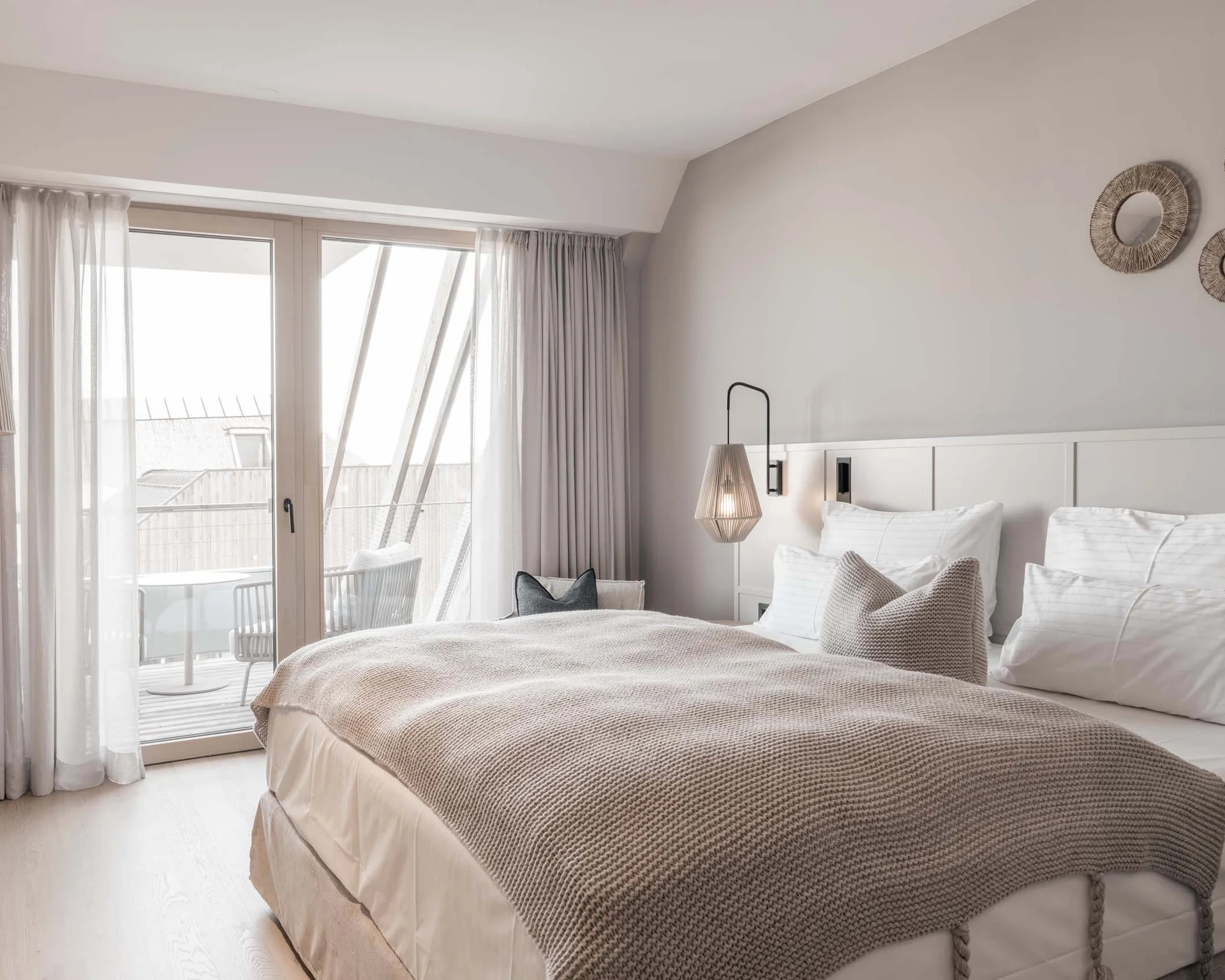 NILS am See: Impressionen eines Orts für das süße Leben Gemütliches Schlafzimmer mit großem Bett, Balkon und warmem, modernem Design