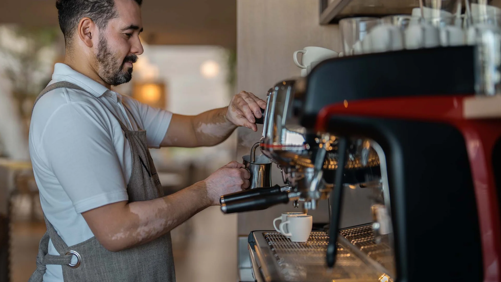 Offene Stellen im NILS am See Barista bereitet Kaffee mit Espressomaschine in einem Café zu