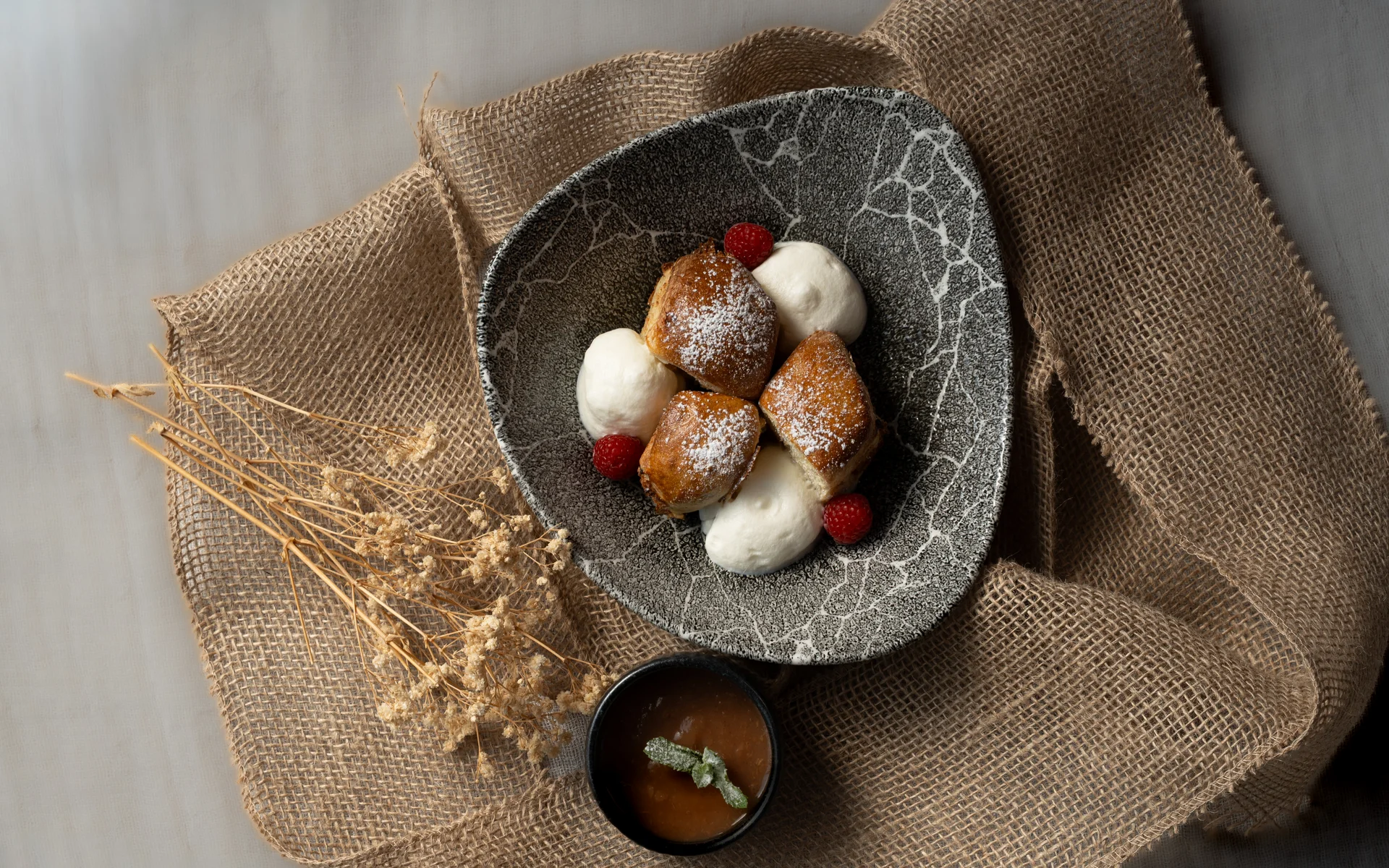 Restaurant Ankkuri am Neusiedler See Dessert mit Sahne, Beeren und Sauce auf strukturierter Stoffunterlage