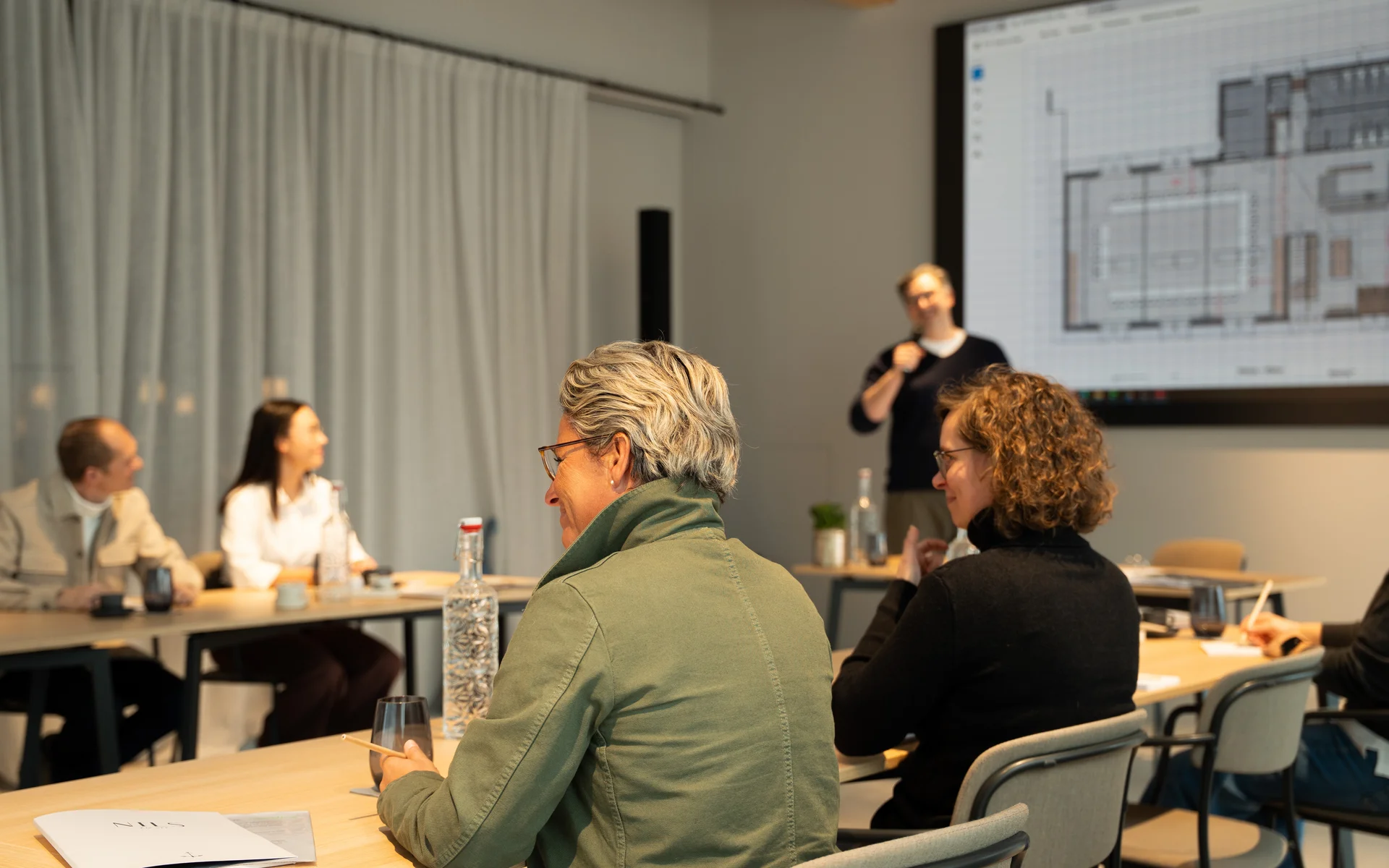 NILS am See: unser Event- und Seminarhotel im Burgenland Menschen bei einer Präsentation in einem modernen Konferenzraum