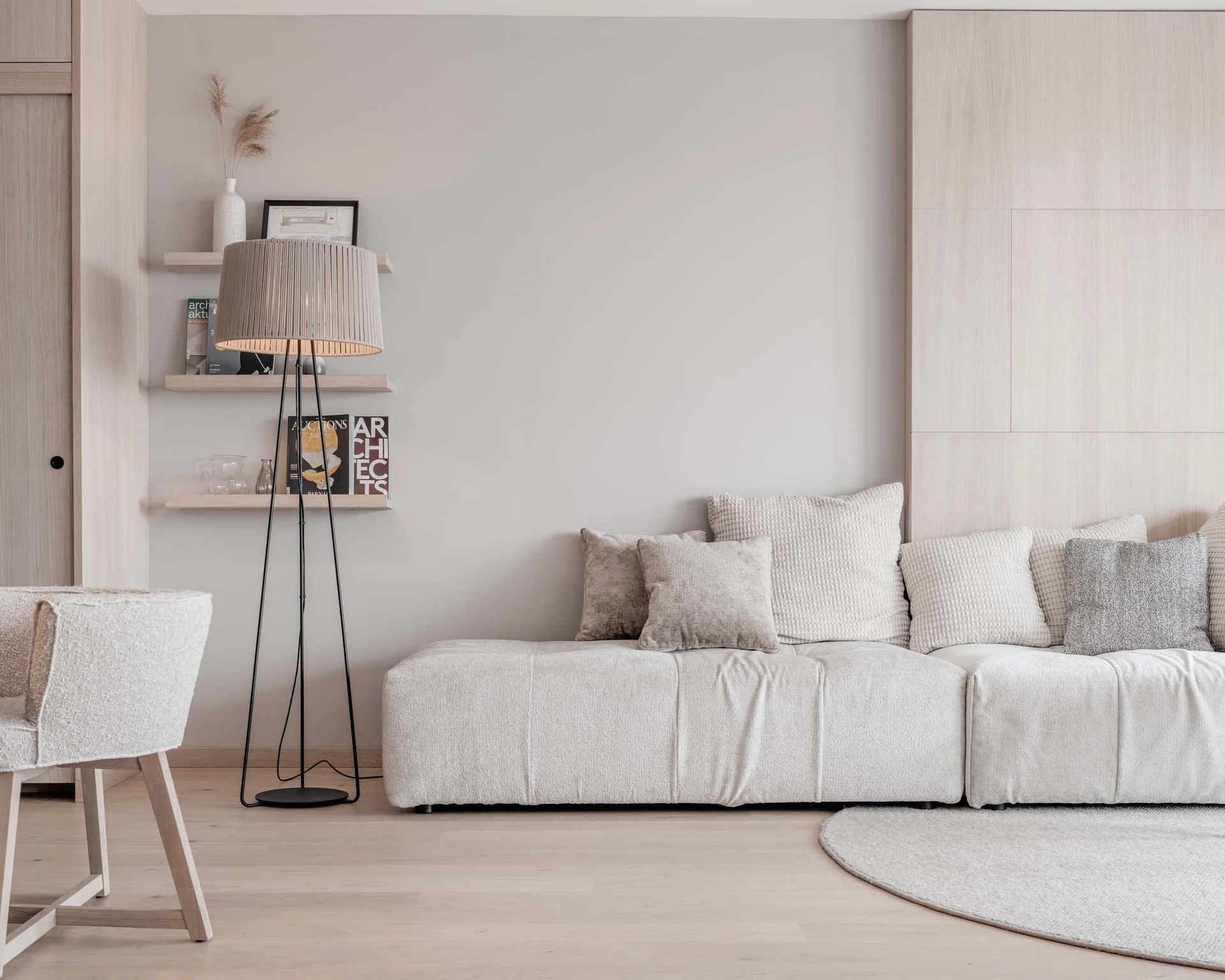 NILS am See: Impressionen eines Orts für das süße Leben Helle, minimalistische Wohnzimmer mit beiger Couch und Stehlampe