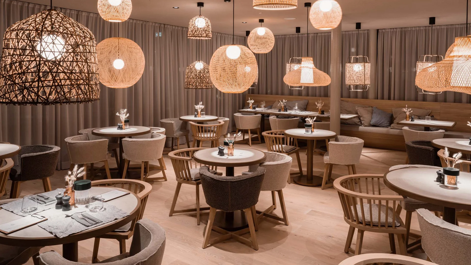 NILS am See: das Boutiquehotel am Neusiedler See Gemütliches Restaurant mit Stühlen, Tischen und warmen Hängeleuchten